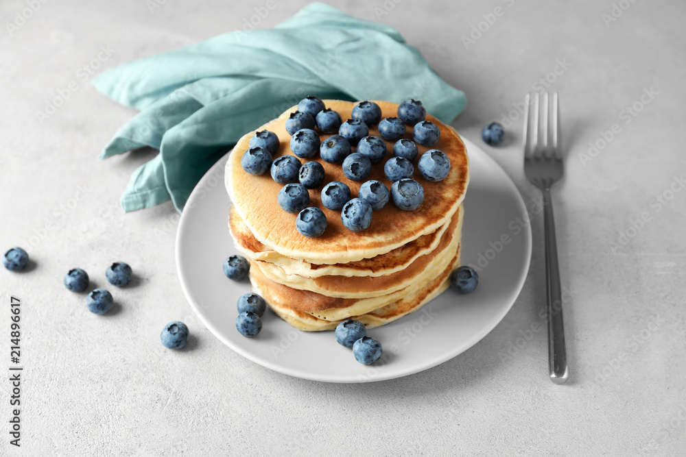 Plate with tasty homemade pancakes and blueberries on table