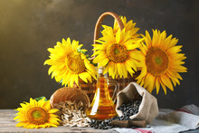 Closeup Photo Of Sunflowers And Sunflower Oil With Seeds On On A Wooden Table. Bio And Organic Concept Of The Product.