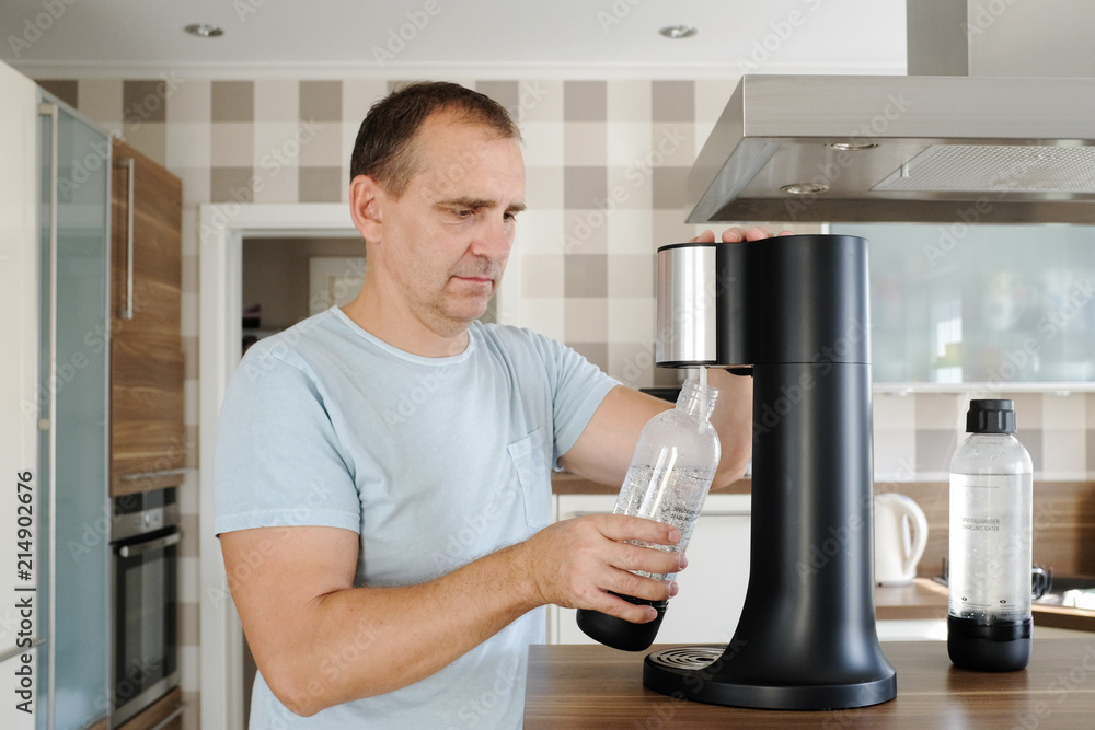 Stock-Foto „mann macht sich sprudelwasser mit einem soda automat“