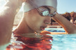 © Jacob Lund - Close up of female swimmer in pool adjusting goggles