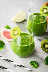 Healthy green smoothie with spinach, kiwi and apple juice in glasses