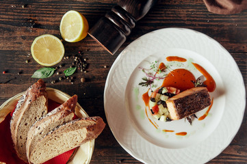 salmon fish grilled steak decorated with bread and lemon at dark wooden background