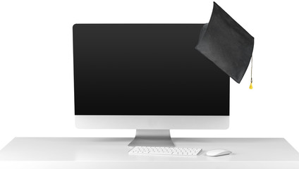 Computer monitor on white table with graduation cap isolated on white