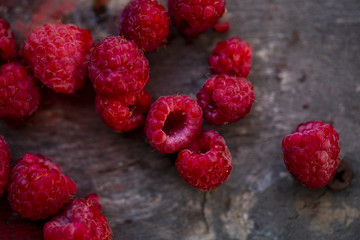 Wall Mural - fresh raspberries scattered on a wooden background