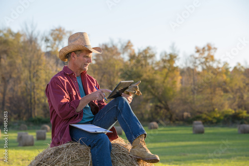 Photographie Rancher Making Notes and Using Digtial Tablet