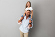 © Drobot Dean - Portrait of little girl having fun and sitting on the neck of her happy father, isolated over gray background