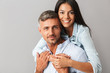 © Drobot Dean - Photo closeup of content european people man and woman in basic clothing smiling and hugging together, isolated over gray background