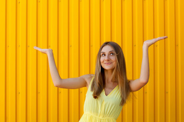 Wall Mural - Pretty young woman holding hands above presenting your product with copy space