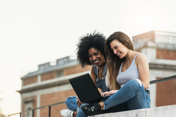 Wall Mural - Beautiful women using a laptop in the Street.