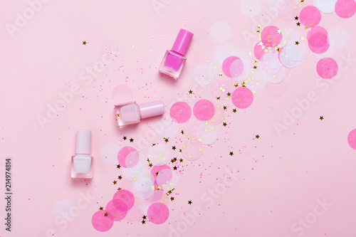Foto Pastel pink nail polishes and confetti, stars and sparkles.