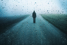 Lonely Man Stands On Misty Road With Artistic Raindrops Background.