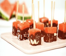 Poster - Watermelon appetizers dipped in chocolate and sprinked with sea salt and almonds on a pink serving board