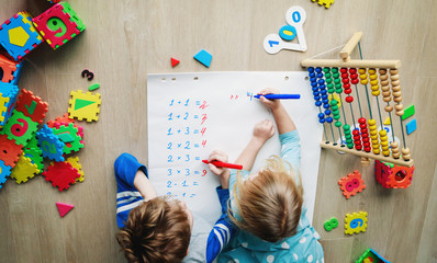 little boy and girl learn to write and calculate numbers