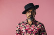 © Carlos David - Simple portrait of mature man with beard and tilted hat, isolated on pink