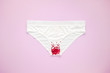 Woman white panties with glitter on pastel colorful background. Menstruation, woman's health, virginity, first sex. Conceptual minimal still life