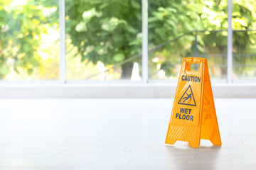 Safety sign with phrase Caution wet floor, indoors