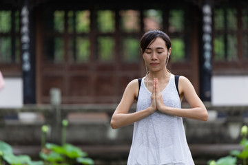 Chinese girl teen hand palms together at chest sign of peace in asian way of zen buddhist.