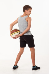 Wall Mural - teenager with a basketball on a white background.