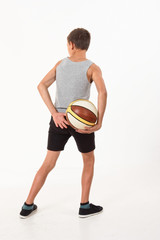 Wall Mural - teenager with a basketball on a white background.