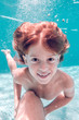 © ADDICTIVE STOCK - Red hair kid smiling under water