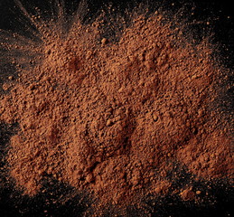 Wall Mural - Cocoa powder pile isolated on black background, top view