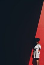 Black Woman In Shadow Against Red Wall