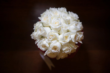 Wall Mural - Top view od white cream roses bouquet for the bride with light spot at center wth dark background