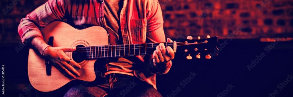 Young man playing guitar  - obrazy, fototapety, plakaty 