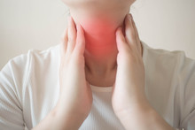 Female Checking Thyroid Gland By Herself. Close Up Of Woman In White T- Shirt Touching Neck With Red Spot. Thyroid Disorder Includes Goiter, Hyperthyroid, Hypothyroid, Tumor Or Cancer. Health Care.
