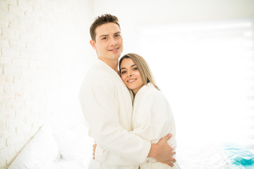 Wall Mural - Couple Wearing Bathrobes While Hugging In Bedroom