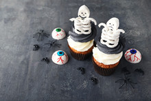 Halloween Cupcakes With Skeletons On Grey Wooden Table
