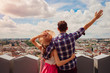 © maryviolet - Young couple of tourists with raised hands looking on Lviv, Ukraine from viewpoint