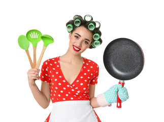 Poster - Funny young housewife with frying pan and cooking utensils on white background