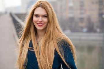 Wall Mural - Portrait of a young beautiful woman in blue coat