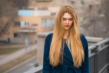 Wall Mural - Portrait of a young beautiful woman in blue coat