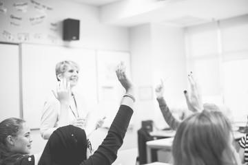 Wall Mural - Students with their hands up responding to their teacher