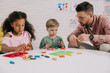 © LIGHTFIELD STUDIOS - multiracial preschoolers and teacher with plasticine sculpturing figures at table in classroom