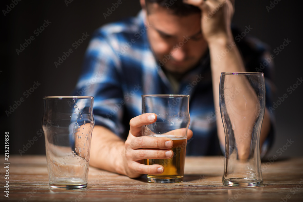 alcoholism, alcohol addiction and people concept - male alcoholic drinking beer from glass at night - obrazy, fototapety, plakaty 