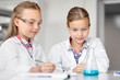 © Syda Productions - education, science and children concept - girls in goggles with test tube studying chemistry at school laboratory