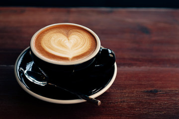 Wall Mural - Cloase up coffee cup on wooden table in coffee shop.