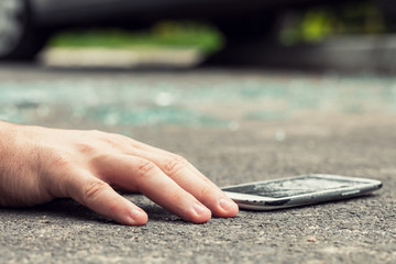 Wall Mural - Close-up of hand of a victim and smartphone after dangerous incident on the road