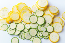 Top View Of Sliced Summer Yellow Squash And Zucchini On White Background