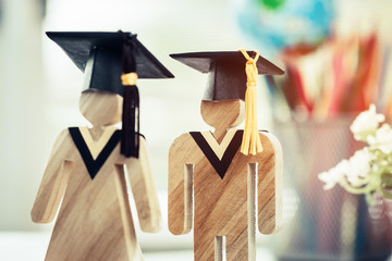 Wall Mural - back to school concept, people sign wood with graduation celebrating cap on open textbook show alter