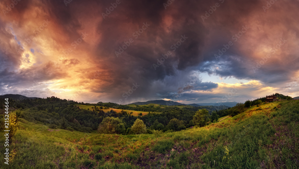 Thunderstorm In The Mountains. Panoramic Summer Landscape With Enchanting Stormy Sky, Storm Clouds, Sunny Valley And Small Rural House.Sunset-Sunrise Landscape With  Beautiful Sky.Stormy Weather.