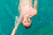Top view of a young Caucasian man swimming back crawl in swimming pool