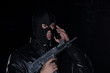 © serikbaib - a man in a mask and with a gun and with a phone