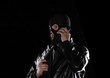 © serikbaib - a man in a mask and with a gun and with a phone