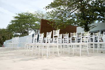 Wall Mural - White chiavari chairs setup on the white sand for modern beach wedding venue with flowers decoration on aisle