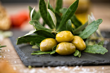 green olives on natural olive tree leaves.