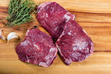 Raw beef cheeks on chopping board